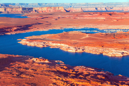 Lake Powell is a reservoir on the Colorado River located in the U.S. The blue water of the lake contrast with the red-brown massifs of the rocks. The photos were taken from the plane.の写真素材
