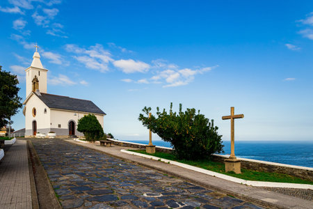 Chapel de la Atalaya and Lighthouse. Beautiful stone paved highway. Atlantic coast, Asturias. Unusual impressive architecture of the Luarca. Romantic trip to Spain.の写真素材