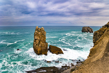 Rocky coastline of the Atlantic Ocean. Portio beach. Stormy autumn day in the Bay of Biscay. The high surf crashes against the shore. Spanish coast, Cantabriaの写真素材