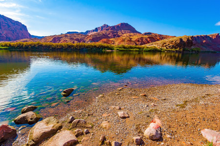 The multicolored canyon of red, orange, and yellow Navajo sandstones. The water of the Colorado River reflects the steep rocks. The historic Lees Ferry on the Colorado River.の写真素材