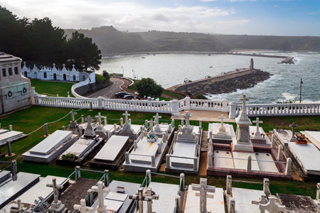 Ancient cemetery over a cliff to the Atlantic Ocean. Luarca is the most beautiful small town in Asturias. Picturesque fishing port in the bay and moored pleasure yachts.  Romantic trip to Spain.の写真素材