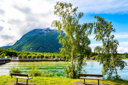 Gorgeous sunny weather in Norway. The huge lake is surrounded by picturesque rounded hills. There are benches on the lake embankment. Travel to fabulous Scandinaviaの写真素材