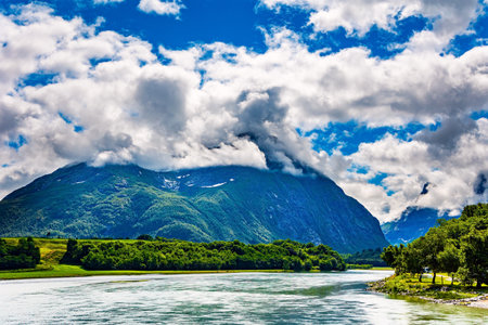 Huge, lovely lake surrounded by picturesque round hills. Wonderful fresh green forrst. Gorgeous sunny weather in Norway.の写真素材