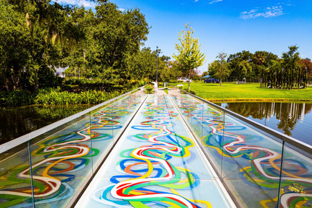 Middle-aged woman with a camera posing on beautiful bridge with mirrored sides. New Orleans. USA. The magnificent City Park.の写真素材