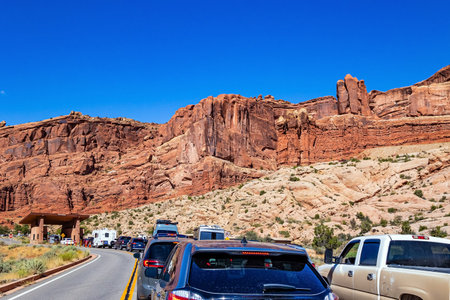 Car queue in front of the park entrance. The Arches. USA. The asphalt highway passes through the most interesting majestic compositions created by wind and water.の写真素材