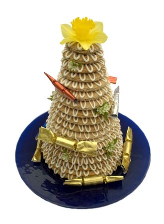 Traditional Scandinavian tower cake (kransekake) made from baked marzipan, decorated with flowers and crackersの写真素材