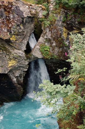 Small waterfall partially covered by the mountain, at Gudbrandsjuvet, Norway.の写真素材