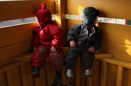 Children dressed in red and blue looking in opposite directionsの写真素材