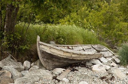 Old wrecked wooden rowing boat on the shore. の写真素材