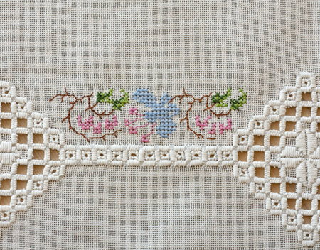 Embroidered cloth on wooden table. With two different types of embroidery.