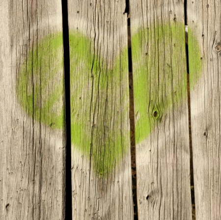 Green grafitti heart on old wood backgroundの写真素材