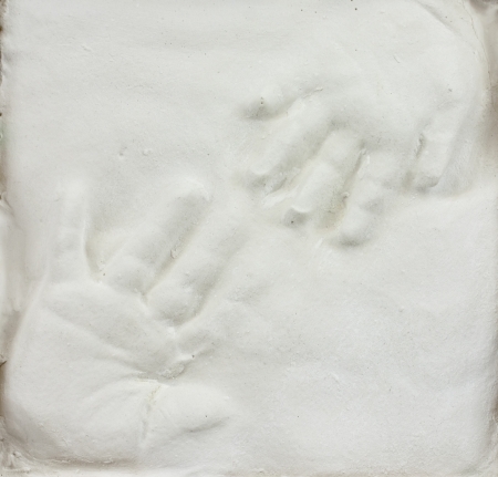 Toddler and baby hand prints in gypsum の写真素材