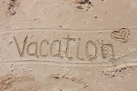 The inscription on the sand - Vacation. Seashells, smooth stones and glass on the beach. Sunny day, summer vacation, weekend, heart. I love rest.の写真素材