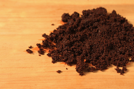 Wet ground coffee texture on wooden background.の写真素材