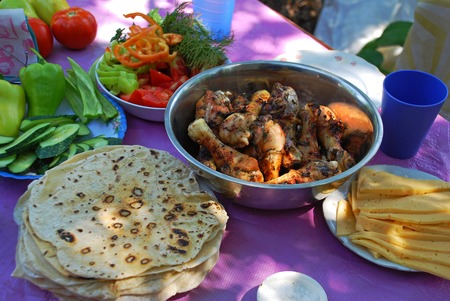 Roasted on fire chiken with herbs, spices and tomato sauce. A delicious and refined way of preparing chiken legs on grill. Armenian bread Lavash.の写真素材