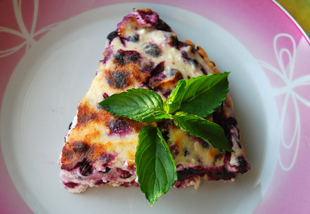 Eaten Cheesecake with bluberries and fresh peppermint leaves on top on a plate. A simple homemade recipe for beginners confectioners.の写真素材