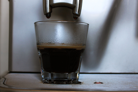 Freshly made espresso with a foam from a coffee machine in a cafe.の写真素材
