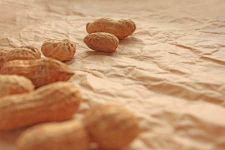 Peanut in a shell on kraft paper, food background of peanutsの写真素材
