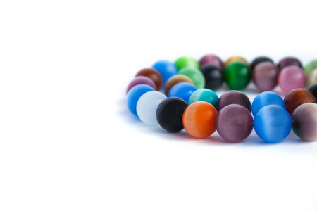 Cats eye quartz necklace and bracelet, selective focus on white background isolated. Colourful precious stones.の写真素材