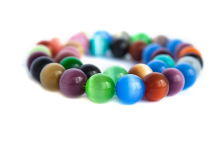 Cats eye quartz necklace and bracelet, selective focus on white background isolated. Colourful precious stones.の写真素材