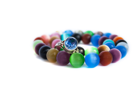 Cats eye quartz necklace and bracelet, selective focus on white background isolated. Colourful precious stones.の写真素材