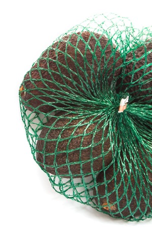 Fresh organic  avocados in a green string bag on a white background isolated, healthy food concept, copy space.の写真素材