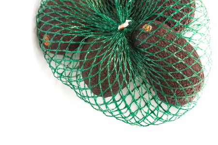 Fresh organic   avocados in a green string bag on a white background isolated, healthy food concept, copy space.の写真素材