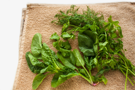 Washed fresh greens on the kitchen towel, healthy lifestyle, eco friendly, raw, vegan background, vegetables diet, copy space, flat lay.の写真素材