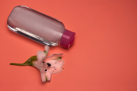 Skincare cosmetic bottle with flowers, cleansing and make-up remove, top view, pastel color background, minimalistic.の写真素材
