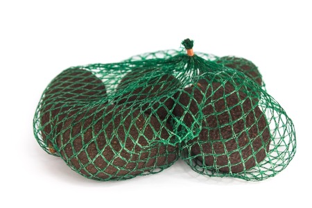 Fresh organic hass avocados in a green string bag on a white background isolated, healthy food concept, copy space.の写真素材