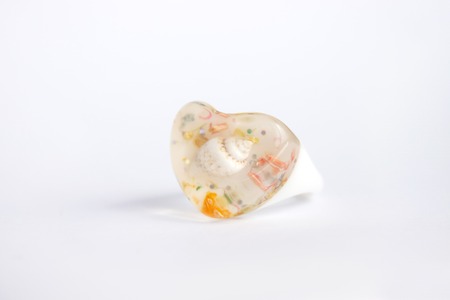Cute heartshaped ring with eexotic sea shell inside, white background, copy space.の写真素材