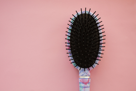 Hair massage comb brush with handle for all types isolated on pink pastel copy space background. Minimalistic flat lay.の写真素材
