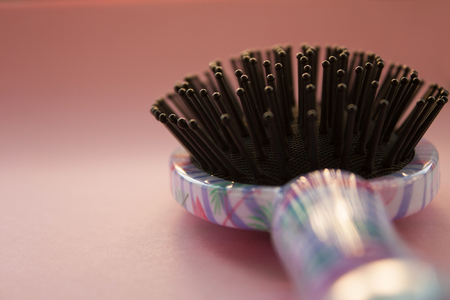 Hair massage comb brush with handle for all types isolated on pink pastel copy space background. Minimalist style.の写真素材