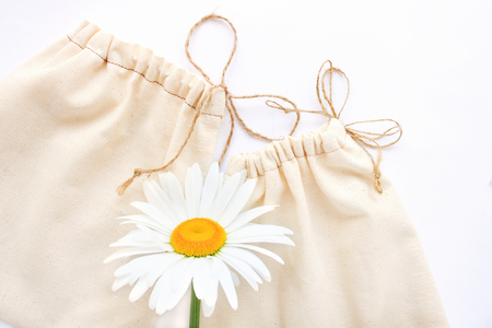 Zero waste concept, reusable cotton bags for free plastic shopping with chamomiles flowers, save the planet.Vegan,healthy, nutrition, eco style living, copy space, white background, flat lay.の写真素材