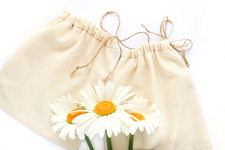 Zero waste concept, reusable hand-made cotton bags for free plastic shopping with chamomiles flowers, save the planet.Vegan,healthy, nutrition, eco style living, copy space, white background, flat layの写真素材