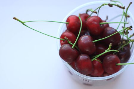 Fresh red cherries in a bowl on pink powder light background. Copy space, minimalistic style. Vegan, raw diet, healthy food concept, summer fruits, vitamins. Close-up yummy cherry.の写真素材