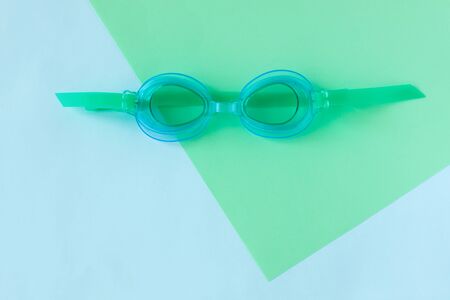 Summer flatlay with watersport goggles, mint and light blue background, minimalistic style, copy space. Sea rest, vacation with family, children's goggles.の写真素材
