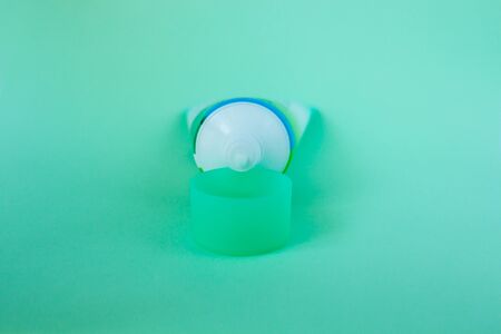 Tube with cream on a pastel mint color background, cosmetics care concept. Pacaging of beauty products, scincare treatments, body lotion, gel, branding mock-up, minimalistic style.の写真素材
