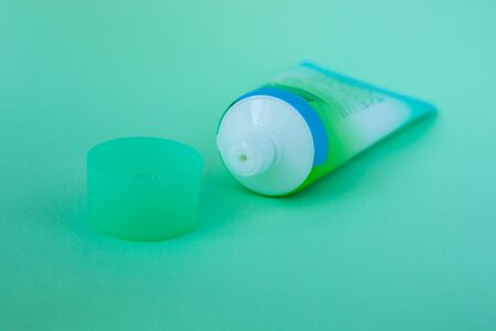 Tube with cream on a pastel mint color background, cosmetics care concept. Pacaging of beauty products, scincare treatments, body lotion, gel, branding mock-up, minimalistic style.の写真素材