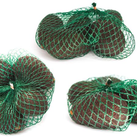 Fresh organic hass avocados in a green string bag on a white background isolated, food collage, photo set, healthy eating concept, copy space.の写真素材