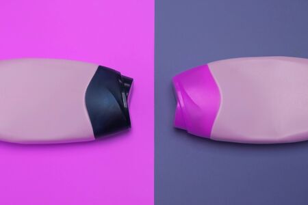 Two packaging bottles of cosmetic products, containers. Beauty, shower, decorative cosmetics. Neon purple colors background, flat lay, top view, minimalistic pop-art style, branding mock up.の写真素材