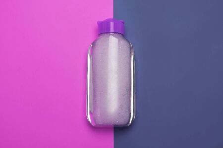 Skincare cosmetic bottle, product for cleansing and make-up remove, top view. Facial tonic, miccelar water for skincare. Mock-up, copy space, purple color background, duotone, minimalistic style.の写真素材
