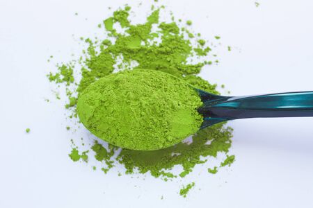 Matcha green tea on light background. A spoon with traditional powdered japanese tea. Healthy drinks, weightloss remedy, energy and antioxidant sourse. Copy space, top view, flatlay.の写真素材