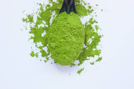 Matcha green tea on light background. A spoon with traditional powdered japanese tea. Healthy drinks, weightloss remedy, energy and antioxidant sourse. Copy space, top view, flatlay.の写真素材