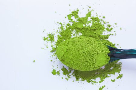 Matcha green tea on light background. A spoon with traditional powdered japanese tea. Healthy drinks, weightloss remedy, energy and antioxidant sourse. Copy space, top view, flatlay.の写真素材