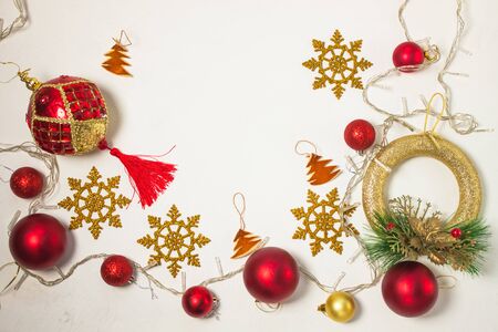 Christmas present box with red ribbon, golden decorations, balls, wreath, snowflakes and lights on a white background. New year 2020 concept, holidays composition, winter flatlay. Top view. Copy space.の写真素材