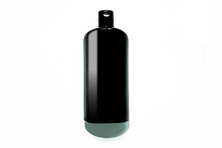 Black cosmetic bottle with natural light shadow isolated white background. Mockup for your brand. Copy space, top view, flatlay, contrasting colors, duotone image.の写真素材