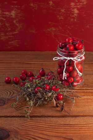 Immunity boosting treatments. Natural thyme, mint herbs and rosehip berries in a jar on a wooden background. Phyto therapy remedies, healthcare infusions.Cold and flu medicine,ethnoscience,homeopathy.の写真素材