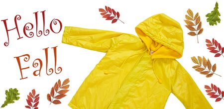Hello Fall website header copy space flat lay.Yellow raincoat on white background isolated. Happy kids outwear autumn style clothes banner. Enjoying rainfall.Happy rainy day concept.Bright rain jacketの写真素材