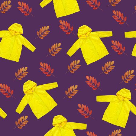 Yellow raincoat, dry autumn leaves on purple background seamless pattern. Grape compote color, outwear style clothes flat lay texture. Hello Fall rainy day concept. Bright kids outdoor rain jacket.の写真素材